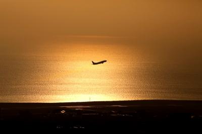 朝陽の中、飛び立つ飛行機